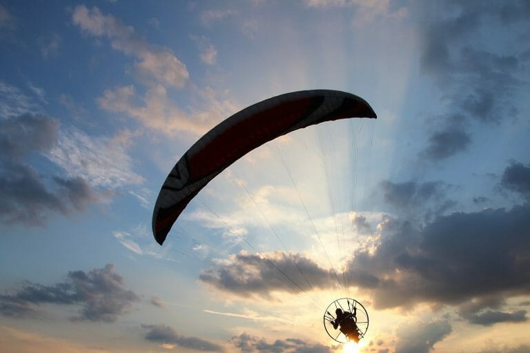 Paraglider silhouette against clouds